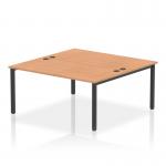 This image shows a sleek and modern office bench desk, with a 2-person setup and a black frame. The desk is made of oak and has a dynamic quality, perfect for a professional and collaborative work environment.