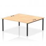 A sleek and modern office space is captured in this picture of the Dynamic Bench Desking Impulse Bench B2B. The 2-person 1800 black frame desk is paired with a maple finish, creating a balanced and professional look. The open design of the bench desk allows for collaboration and productivity in the workplace.