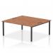 The photograph captures a sleek and modern two-person bench desk with a striking black frame and a warm walnut finish. The dynamic design allows for comfortable and functional use in any office space.