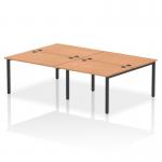 This image features a dynamic bench desking setup with four workstations, each with a black frame and oak desktop. The modern design of the impulse bench is perfect for any office space.