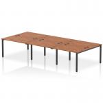 This photograph features six people working at a modern office bench desk. The bench has a sleek black frame and a warm walnut finish, giving it a professional yet inviting look. The dynamic design allows for collaborative work and promotes productivity.