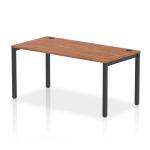 This photo showcases a sleek and modern office space with a dynamic bench desking setup. The black frame and walnut finish of the Impulse Bench Single Row 1600 add a touch of sophistication. The spacious desk is perfect for productivity and collaboration in any professional setting.