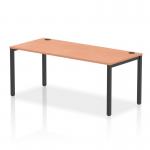 The photo shows a modern, sleek bench desk consisting of a black metal frame and a long row of individual beech desks. The work surface is arranged in a dynamic manner, allowing for a collaborative and productive office space.