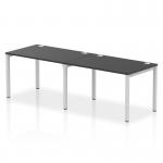 In the photo, a sleek and modern bench desk with a silver frame is shown. It features a single row of two workstations, each with a spacious 1200mm surface, perfect for collaboration. The black desk surface adds a touch of sophistication to any office space.