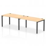 This picture features a dynamic bench desking setup with a single row and 2 person capacity. The sleek black frame complements the warm maple desk surface, creating a modern and stylish office space.