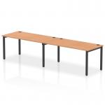 This image shows a modern office bench desk with a black frame and oak surface. The bench is designed for two people, creating a dynamic and collaborative work space. The clean lines and sleek design suggest a professional and efficient atmosphere.