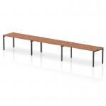 This photograph showcases a sleek and modern office space, complete with a dynamic bench desking system. The Impulse bench features a single row with seating for 3 people, a black frame, and a stunning walnut finish on the desk surface. The overall design exudes professionalism and functionality.