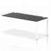 The photograph shows a sleek, modern office space with a row of dynamic bench desk add-on units equipped with a single row extension kit. The desk has a white frame and the bench itself is black, creating a professional and stylish look.