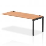 In this image, we see a row of sleek black bench desks, with a single extension kit and an oak tabletop. The desks dynamic design and sturdy frame make them a functional addition to any modern office space.
