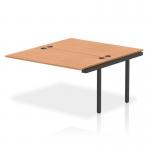 The image shows a sleek and modern bench desk with black frame and a combination of oak and white surfaces. The dynamic bench desk add-on units add extra functionality and the B2B ext kit extends the length to 1400mm. Perfect for any office space looking for a contemporary and practical workstation.