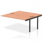 The picture shows a sleek and modern bench desk with an add-on unit, in a professional black frame. The desk is part of the Impulse Bench B2B line and has an extension kit that adds 1600mm to the length. The surface is made of warm and natural beech wood. It would be a stylish addition to any office space.