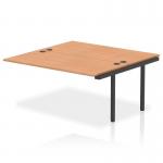 The image shows a sleek and modern office bench desk with a black frame and oak tabletop. Additional dynamic bench desk add on units are seen attached to the main desk, providing extra workspace. This versatile and practical desk is perfect for any office setting.