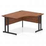 In the photo, you can see a sleek and modern Dynamic Right Hand Desks Impulse 1400mm Right Crescent Office Desk. The desk features a beautiful walnut top and is supported by sturdy black cantilever legs. The overall design exudes a sense of sophistication and professionalism.