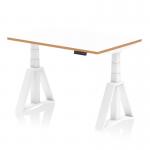 The image shows a sleek and modern Dynamic Sit Stand and Height Adjustable Desk in Oslo design. The desk has a white top with a natural wood edge, supported by a white frame and a Piste Foot for extra stability. The 1200mm size offers ample working space. Perfect for a versatile and ergonomic office setup.