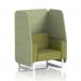 The photo captures a vibrant dynamic booth with a single seater open design. The white legs contrast beautifully with the rivet fabric and burnish panels. A stunning olive sofa adds a pop of color. Custom-made for Brixworth, this booth is truly one-of-a-kind.