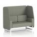 The image shows a sleek and modern open booth with white legs, featuring vitreous panels and a comfortable 2-seater sofa in rivet fabric. This dynamic booth is customizable and made to order, perfect for any modern office or event space.