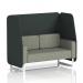 This photo shows a stylish and modern Dynamic Booth in Brixworth design. The 2-seater open booth features sleek white legs and is upholstered in a striking charcoal fabric with rivet details. The panels are a dark, elegant shade of charcoal, while the sofa is finished with a glossy vitreous material.