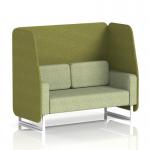 The image shows a dynamic booth with a two seater open design and white legs, custom-made in Brixworth. The booth features olive panels and a burnish sofa in rivet fabric, creating a stylish and modern look.