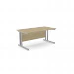 This image features a spacious urban oak rectangular desk, measuring 1600mm x 800mm, with sleek silver metal legs and a clean, modern design. Perfect for any office or workspace in need of a professional and functional update.