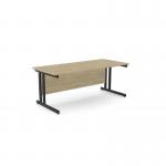 This picture features a modern office setting with two rectangular desks made of ashwood and supported by twin metal legs. The desks measure 1800mm x 800mm and have a sleek urban oak finish with a contrasting black trim.