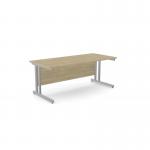 The image shows a spacious office set-up with sleek, rectangular desks made of urban oak. The sturdy metal legs add a modern touch to the overall design.