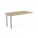 This photograph showcases a modern and functional office bench desk with sleek add on units. The urban oak finish adds a touch of sophistication while the silver accents bring out a contemporary vibe. Narrow design with wide portal top offers ample workspace for one person.