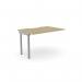 The picture shows a sleek office bench desk with add-on units. Its scallop top is made of urban oak, giving it a stylish look. This desk is designed for one person and measures 1000 x 800. The add-on units are in a modern silver and urban oak color.