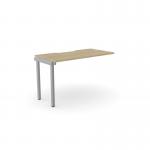 The photo captures a modern desk unit with a sleek urban oak finish. Its scallop top adds a touch of elegance to its design, while its added units provide extra space for work essentials. The silver accents add a stylish touch to the overall aesthetic of the workspace.
