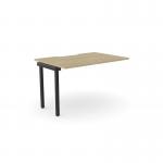 The photograph shows an urban oak bench desk with add-on units, scallop top, and black accents. It comfortably accommodates one person and measures 1200 x 800. The C-sense 1 person add-on unit seamlessly blends with the desk, creating a sleek and functional workspace.