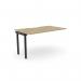 This photo captures an office bench desk with add-on units, featuring a scallop top in urban oak with a black finish. The sleek design and spacious 1400 x 800 size make it a functional and modern addition to any workspace.