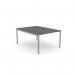 The photo showcases an expansive open leg office bench with a sleek graphite finish. Its scallop top design adds a touch of elegance, while the 1200 x 800 dimensions provide ample working space for one person. Silver accents can be seen on the legs, giving the bench a modern look.