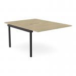 This photo features two sleek C-sense bench desk add-on units, with scalloped tops, in a chic Urban Oak finish. The units are designed to comfortably accommodate two people and measure 1200 x 800. The sophisticated black legs provide a modern contrast against the warm wood tone.