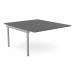 The picture shows a sleek and modern office bench desk, with add-on units that provide additional space and functionality. The desk has a scalloped top and is finished in a stylish graphite shade with silver accents. It can accommodate two persons and measures 1400 x 800.