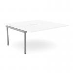 The photo shows an office bench desk with add-on units that can accommodate two people. The scallop-shaped top is 1600 x 800 in size and features a clean white finish with silver details.