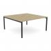 The photo shows a modern and versatile open leg desk, designed to accommodate two people. It features a sleek scallop top surface in an urban oak color, paired with elegant black legs. This office bench provides ample space for work and collaboration.