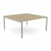 In this photograph, you can see an Urban Oak SLV CSE-2PB-LEO-TS1680/UO/SLV Edit Office Bench Desking C-sense 2 Person Bench with an open leg design and a scalloped top measuring 1600 x 800. The modern yet natural look of the urban oak and the sleek silver legs give off a professional and inviting vibe. This spacious bench offers enough room for two people to comfortably work side by side.