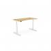 The photo shows a round, height-adjustable desk with a curved bamboo top and a white frame. The office sit-stand desk is 1400 x 700mm and perfect for a modern workspace. It can be adjusted to suit different heights and positions for a comfortable and ergonomic work experience. The sleek design adds a touch of style to any office setting.