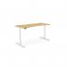 The photo shows a modern and versatile office space, featuring a round height-adjustable desk with a curved bamboo top and a sleek white frame. The desk measures 1600 x 700mm and is perfect for a standing or sitting work position. The design exudes functionality and elegance.