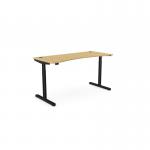 The photo shows a rounde height-adjustable desk with a rectangular bamboo top and black frame. The desk is 1600x700mm in size and can be used for sitting or standing while working. The design is simple and modern, making it a great addition to any office space. The bamboo top adds a touch of warmth and sustainability to the overall look.