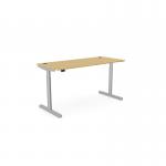 The picture shows a stylish and functional office setup, featuring a round, height-adjustable desk with a 1600 x 700mm rectangular bamboo top and a silver frame. The desk allows for both sitting and standing positions, providing ergonomic support and versatility.