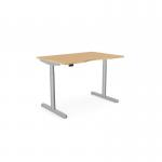 The photo shows a versatile office desk with a round shape and a double purpose scallop. It is height adjustable and can be used while sitting or standing. The desk has a beech top and a silver frame, measuring 1400 x 800mm.