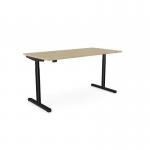 The photo shows an office space with a round height-adjustable desk, featuring an urban oak top and black frame. The desk has an aluminum portal for cables and measures 1800 x 800mm. It offers both sitting and standing options for customizable comfort.