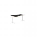 The photograph shows a sleek office space with a variety of sit-stand and height adjustable desks. The desks feature a Kay top in Zoom grey with black legs, measuring 1600 x 800. One of the desks is left-handed, with a black top and silver legs. The office appears modern and professional.
