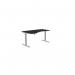 The photo captures a sleek and modern office set up with edit office sit stand and height adjustable desks. The spacious 1600 x 800 desk features a striking blue top and is supported by white adjustable legs. Its ergonomic design promotes a comfortable and versatile workspace, perfect for any left handed individual. The addition of the Kay Top Height Adjustable Zoom provides extra functionality and style to the desk.