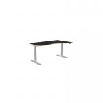 The image displays a spacious office setting with a combination of sit-stand and height adjustable desks. The desks feature a sleek white frame and a blue top, providing an ergonomic workspace. The right-handed desk measures 1600 x 800 and is equipped with a zoom feature for personalized height adjustment.