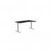 The image displays a spacious office setting with a combination of sit-stand and height adjustable desks. The desks feature a sleek white frame and a blue top, providing an ergonomic workspace. The right-handed desk measures 1600 x 800 and is equipped with a zoom feature for personalized height adjustment.