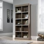 In the photograph, the Teknik Bookcases Barrister Home Tall Bookcase stands tall at W903 x L343 x H1906mm. With its inviting salt oak finish, the bookcase exudes a warm and natural feel. Its shelves are perfectly organized, showcasing an array of books and decorative items. The sleek design and sturdy construction make it a practical and stylish addition to any home or office space.
