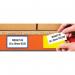 The photograph shows the vibrant yellow Beaverswood Supply Ltd warehouse signage, with the words Beaverswood Magnetic PVC Clear Front Ticket Pouches printed in bold letters. The pouches are neatly arranged on warehouse shelving and racking, each measuring 60mm in height and 100mm in width. A pack of 100 pouches is displayed in the foreground, ready for use.