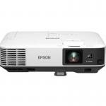 The photo shows a sleek, black Epson projector with the brand name prominently displayed on the front. The projector is set up on a table, with its lens facing forward and its various ports and buttons visible on the side. The image being projected onto the screen is bright and clear, thanks to the 5000 ANSI lumens and 3LCD technology. The display is in WUXGA 1920 x 1200 pixels resolution, creating a sharp and detailed image. Various cords and cables are connected to the projector, including HDMI, VGA, DisplayPort, and USB, providing many options for seamless connectivity. The overall design is modern and professional, making it suitable for a variety of multimedia needs.