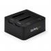 This picture shows a StarTech Dual-Bay USB 3.0 to SATA and IDE Hard Drive Docking Station. The black docking station has two slots for hard drives, with USB and power ports on the side. It also features a red on/off switch and LED indicator lights.